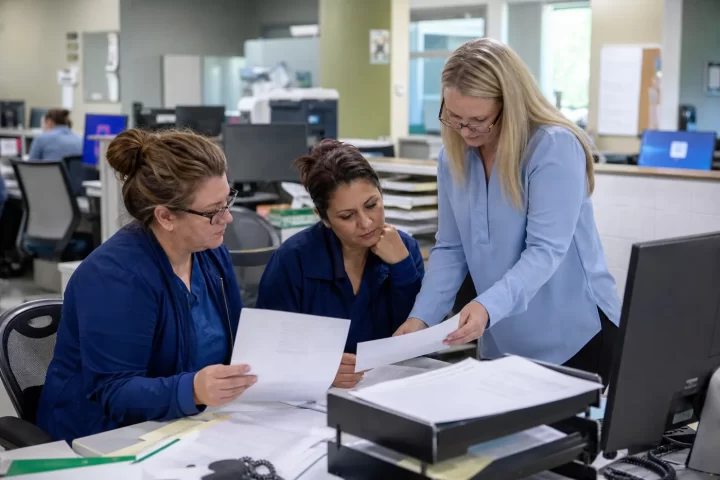 Medical practice billing team reviewing service costs and reports