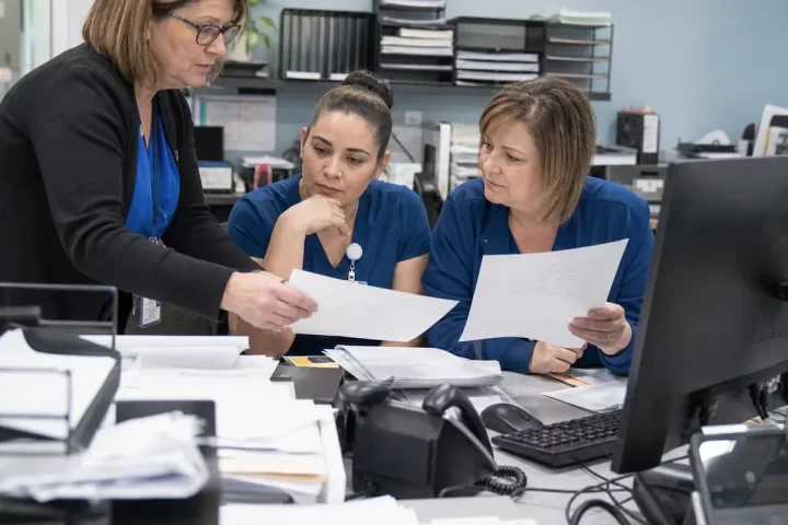 Oncology practice administrators reviewing revenue cycle workflow