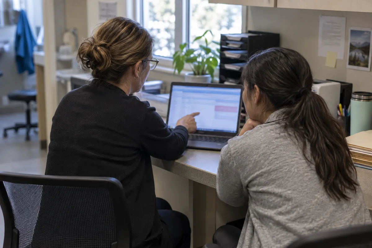 Medical office administrative staff reviewing a claim exception on a laptop
